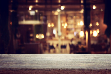 Naklejka na ściany i meble background Image of wooden table in front of abstract blurred restaurant lights