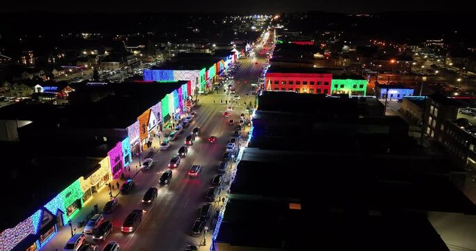 Rochester, Michigan skyline at night lit up with Christmas lights on buildings and drone video moving forward.