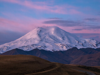 Purple majestic dawn over Mount Elbrus. Snowy mountain peaks at