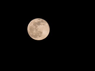 Close up of full moon seen with the telescope from northern hemisphere. Black night sky background.