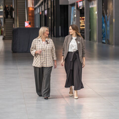 Two middle-aged women walking in the mall