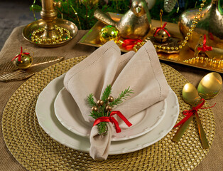 New Year's table setting in gold color with a linen napkin