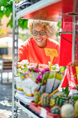 Obraz premium A woman buyer selects bouquets before buying at a flower shop on the street