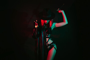 sexy woman in beautiful underwear in a hat holding a leather whip flogger and handcuffs for BDSM...