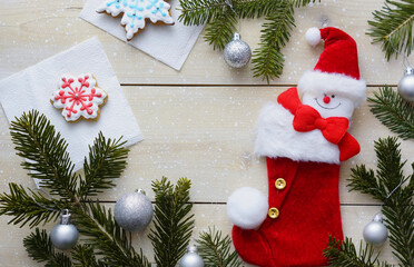 New Year's background with New Year's twigs, a snowman, a red sock, Christmas pears and cookies.