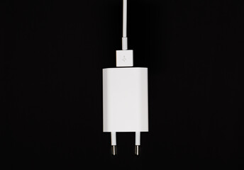 White USB mobile charging cable with adapter isolated on black background