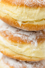Close up macro shot of stack of Krapfen or Berliner doughnuts dusted with icing sugar, traditional...