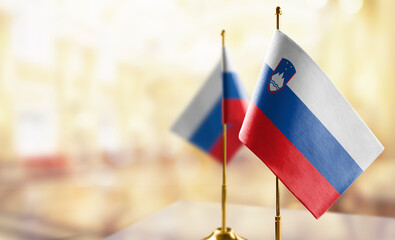 Small flags of the Slovenia on an abstract blurry background