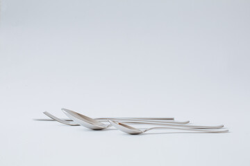 Stainless steel cutlery set, knife, spoon, fork, teaspoon on a white background, copy space