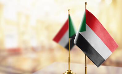 Small flags of the Sudan on an abstract blurry background