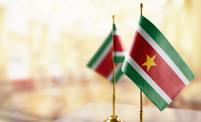 Small flags of the Suriname on an abstract blurry background