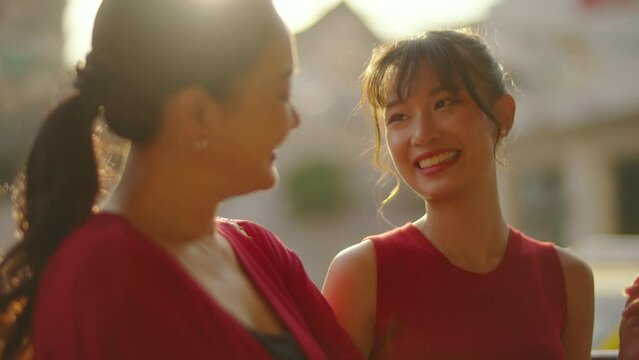 4K Portrait of Happy Asian woman mother and daughter enjoy and fun outdoor city lifestyle travel and shopping together at Chinatown street market on Chinese lunar new year holiday vacation at sunset.