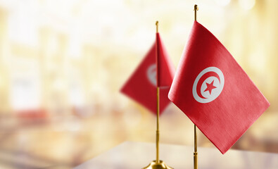 Small flags of the Tunisia on an abstract blurry background