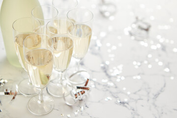 Champagne glasses and bottle placed on white marble background