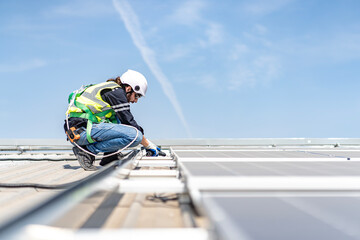 Male engineer installing or checking the working condition of solar panels on the roof or at the height of the factory for saving electricity was broken to use renewable energy from the sun