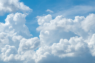 Naklejka na ściany i meble White fluffy clouds on blue sky. Soft touch feeling like cotton. White puffy cloudscape. Beauty in nature. Close-up white cumulus clouds texture background. Sky on sunny day. Pure white clouds.