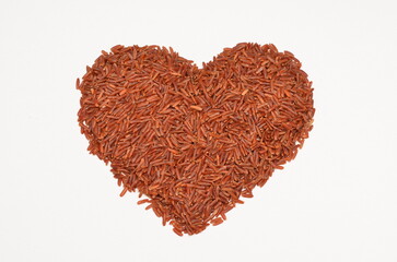 Obraz na płótnie Canvas heart shaped pile of brown rice isolated on white background