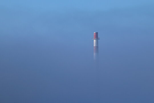 Factory chimney in the clouds, inversion