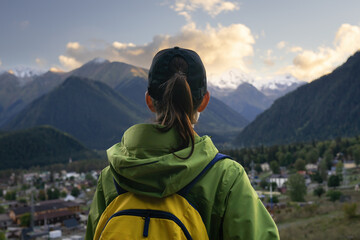 Rear view of woman hiker with backpack on a hiking trip in mountains