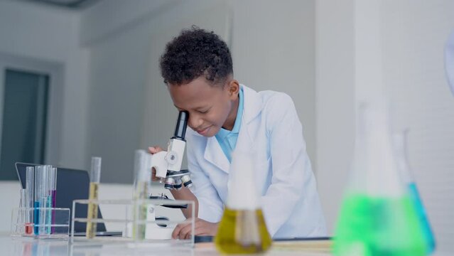 4K, school children in science classroom, doing chemistry science experiments, male school children using microscopes, looking at foreign objects stuck in water, excited expression on experiment.