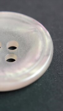 vertical video animation - close up of single transparent white  plastic button