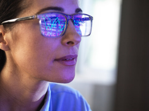 Female expert in glasses looking at screen with financial data