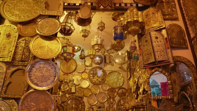 Street shot of carved cooper lamps hanging on the walls along with mirrors and icons. Traditional oriental souvenirs lamps and secular decorations.