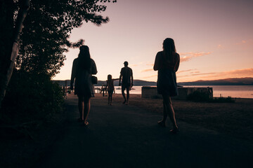 USA, Tahoe City, Rear view of people walking near Lake Tahoe at sunset