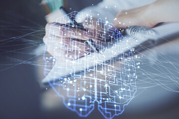 Multi exposure of writing hand on background with brain hologram. Concept of self learning.