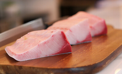 Hamachi raw fish on wooden plate.