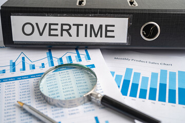 Overtime. Binder data finance report business with graph analysis in office.