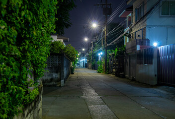narrow and empty street at night with lamppost