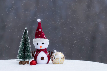 Christmas Toy Snowman:A fun toy snowman in a scarf with Christmas decorations on a snowy background.