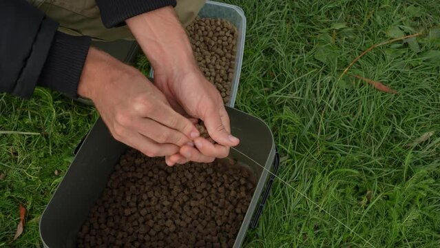 Putting ground bait into a method feeder basket