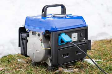 Working generator outdoors in winter. Using gasoline generator during blackouts in Ukraine during...