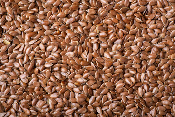 Flat background of linen seeds. Dried linen grain background - obrazy, fototapety, plakaty