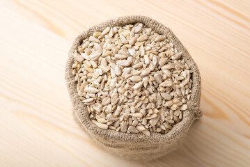 Peeled sunflower grain in linen sack. Beautiful composition of white peeled sunflower seed in bag