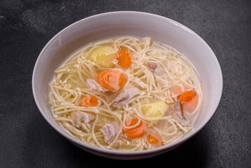 Delicious soup with noodles, chicken and carrots with spices and herbs