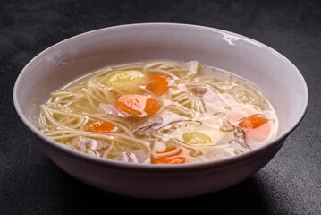 Delicious soup with noodles, chicken and carrots with spices and herbs