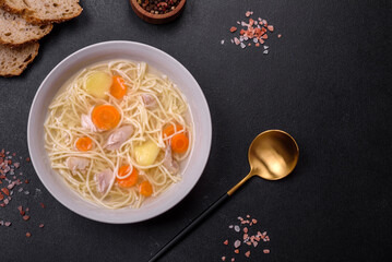 Delicious soup with noodles, chicken and carrots with spices and herbs