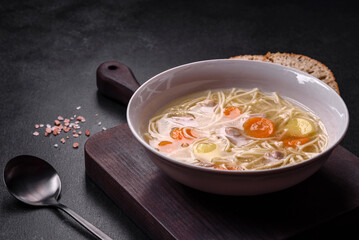 Delicious soup with noodles, chicken and carrots with spices and herbs