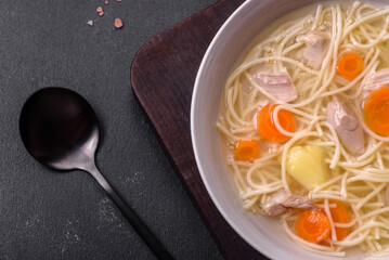 Delicious soup with noodles, chicken and carrots with spices and herbs
