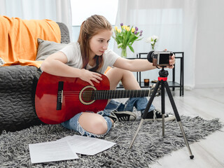 Girl teenager with guitar recording streaning with camera