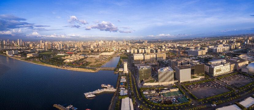 Panorama Photoo of Manila Cityscape in Philippines. Blue Sky and Sunset Light. Pier in Foreground. Business District.