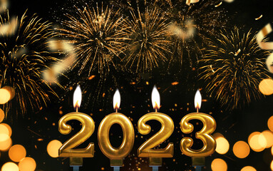 New Year's Eve 2023. Gold candles 2023 burning on a black background with fireworks and confetti....
