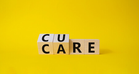 Cure and Care symbol. Turned wooden cubes with words Care and Cure. Beautiful yellow background. Business and cure and care concept. Copy space