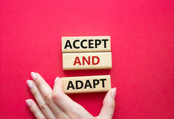 Accept or adapt symbol. Wooden blocks with words Accept and adapt. Beautiful red background....