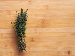 Bundle of fresh thymes on a wooden background.