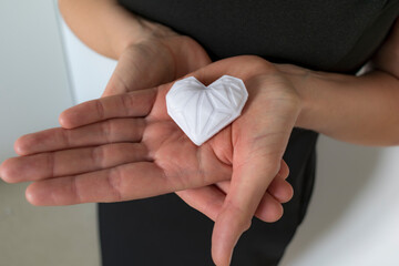 Woman holding white 3d printed heart. Ideal for diverse concept : love and health, gratitude and charity either technology