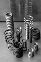 Different sizes of springs. Metal background. Black and white. 